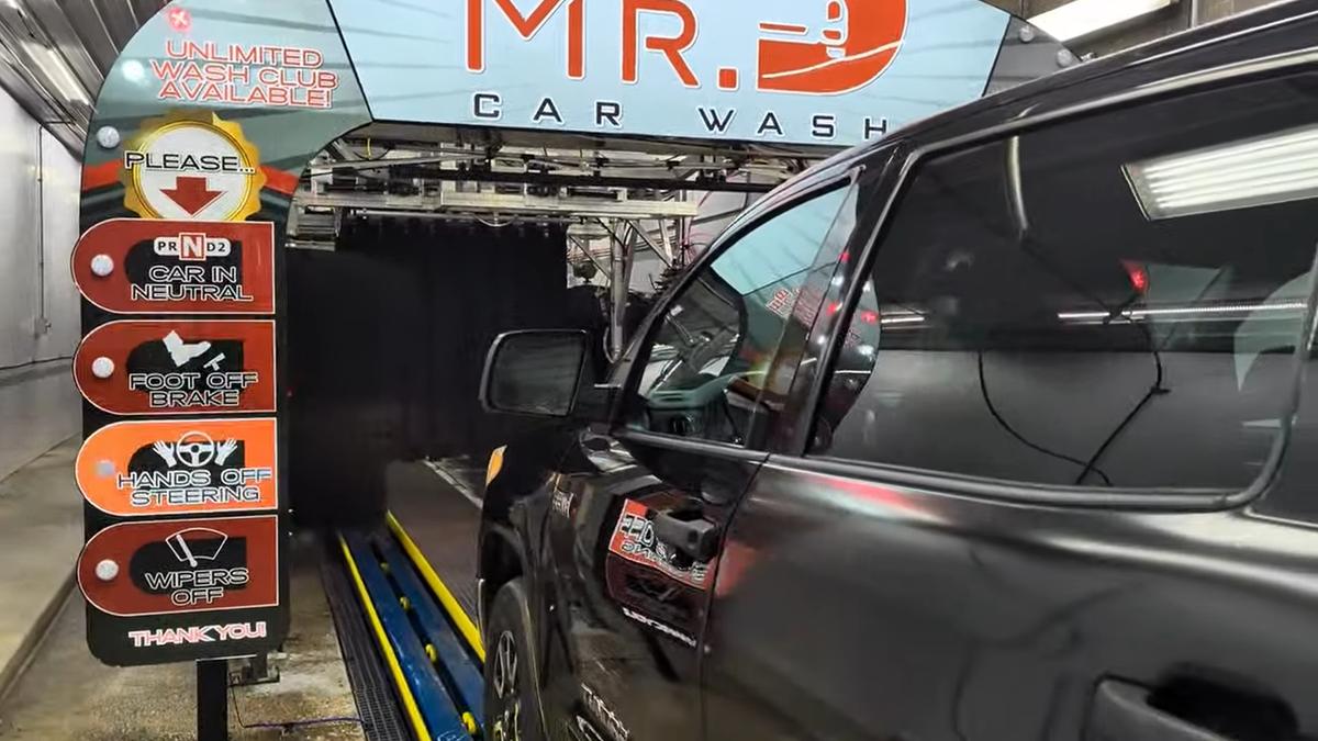 A pickup truck pulling into the Mr. D Car Wash tunnel entrance