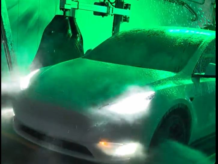 A white car covered in foam inside the Mr. D tunnel